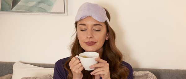 Woman sitting in bed holding cup